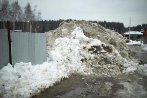 la valla está cubierta de nieve. quitado la nieve al lado de la carretera. foto