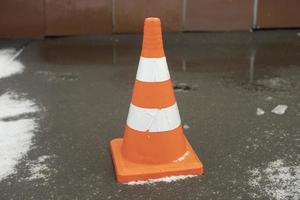 gorra naranja en la carretera. Señal de advertencia. limitador de movimiento zona vallada. foto