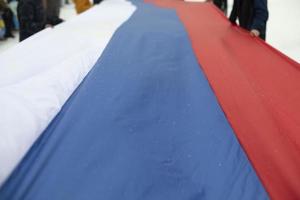 Flag of Russia. People hold fabric. photo