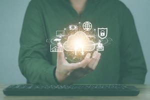 cloud computing concept man's hand holding a virtual image cloud storage which is a form of digital computer data storage That helps facilitate both small and large organizations as well photo