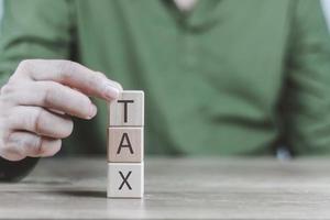 e-tax Invoice conceptman's hand is building a cube wood including debit note, credit note and receipt to be in electronic form with digital signature or time stamp photo