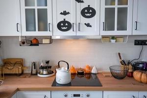 el interior de la cocina blanca de estilo escandinavo está decorado con calabazas para halloween. estado de ánimo otoñal, decoración del hogar para las vacaciones foto