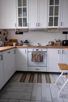 cocina blanca y acogedora en estilo loft scandi. interior de la casa, diseño de comedor, horno, vitrocerámica, mesa, muebles de cocina foto