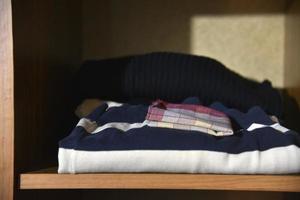 Stored underwear and clothes in the closet. Clothes put on a shelf in the closet. photo