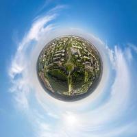 tiny planet in sky with clouds overlooking old town, urban development, historic buildings and crossroads. Transformation of spherical 360 panorama in abstract aerial view. photo