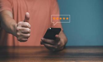 Hands of Client holding and giving a Five Star Rating feedback and raisd thumbs up, Customer Experience Concept, Best Excellent Services for Satisfaction. photo