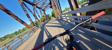 una bicicleta de montaña de los ciclistas prospectivos en un puente ferroviario foto