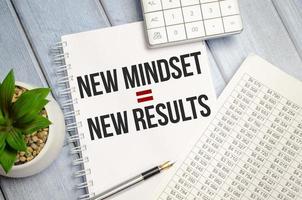 New Mindset - New Results on paper notebook and charts with calculator photo