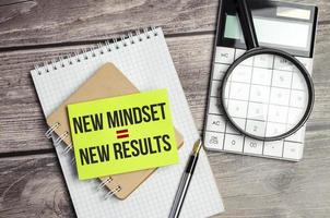 New Mindset - New Results on green sticker and notebook with calculator photo