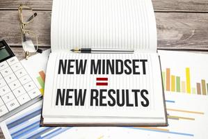 New Mindset - New Results on paper notebook and charts with calculator photo