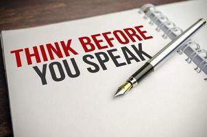 think before you think words on white paper and pen on wooden background photo