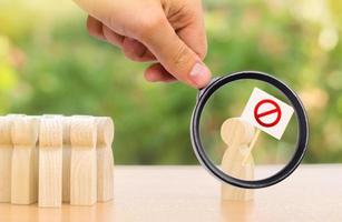 A magnifying glass looks at a person with a poster protests and draws public attention to the problem. Social discontent and tension, strike, disagreement. Indicative protest against society photo