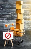 Trading cart with boxes and an easel with a prohibition symbol NO. Internet trade online shopping ban. Restriction on importation goods, proprietary for business. Sanctions and economic restrictions photo