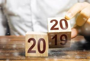 Two wooden blocks with numbers 2019 and 2020. Concept beginning of new year. New objectives. in next decade. Trends in the world. Build plans and goals. Moving into the future for new opportunities photo