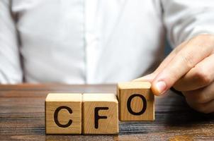 A man makes the word acronym abbreviation CFO. Chief Financial Officer. Financial management in business and company. Risk. Development and growth. Appointment to a new post, promotion. photo
