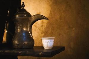 Dubai, UAE , 2022 - Top view coffee set up on silver plate of two cups and dates in bowl in coffee museum in Dubai photo