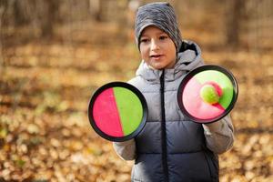 retrato al aire libre de otoño de niño con juego de pelota catch and toss. foto