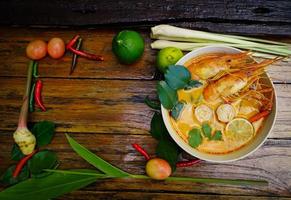 Tom yum kung in a cup on a wooden floor, Tom yum kung is also the national dish of Thailand.  And is a food that is famous all over the world. photo