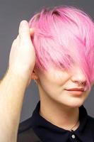 Hairdresser checking woman's pink hairstyle. photo