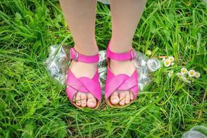 Legs of a little girl tramples a plastic bottle photo