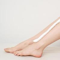 Bare legs with shaving foam photo