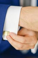 Groom or businessman fasten cufflink photo