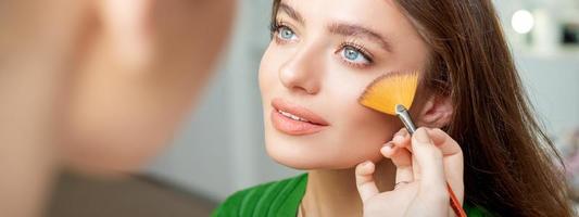 Professional make up artist applying powder photo