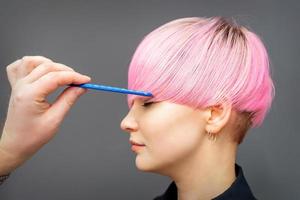 Hairdresser checking woman's pink hairstyle. photo