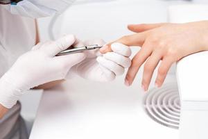 Close up of manicurist using manicure cutter photo