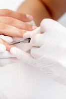 Woman receiving nail care procedure photo