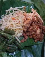 Nasi Kucing, food with small portions typical of Central Java. Contains rice, stir-fried vegetables, usually chickpeas, stir-fried tempeh, soy sauce, and fried noodles. photo