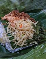 Nasi Kucing, food with small portions typical of Central Java. Contains rice, stir-fried vegetables, usually chickpeas, stir-fried tempeh, soy sauce, and fried noodles. photo