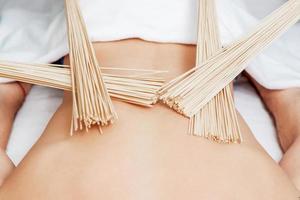 masaje de espalda con escobas de bambú foto