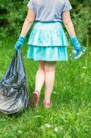 Little girl cleans plastic trash photo