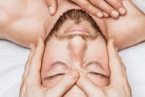 Man receiving relaxing head massage. photo