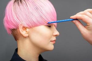 Hairdresser checking woman's pink hairstyle. photo