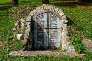 old weathered door in the wooden wall of an ancient hut photo