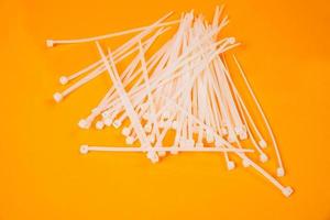 nylon cable ties in glass in jar in bucket on orange background photo