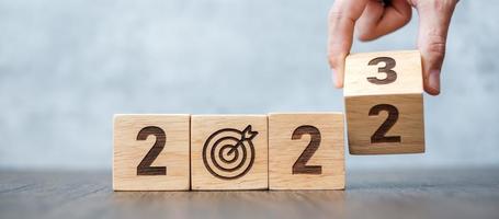 hand flip 2022 to 2023 block with dartboard sign. Business Goal, Target, Resolution, strategy, plan, Action motivation, change, thinking, countdown and New Year start concepts photo