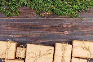 Christmas fir tree branches with gift box on dark rustic wooden background with copy space for text photo