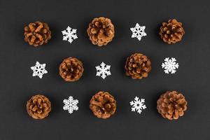 Top view of holiday composition made of pine cones and white snowflakes on colorful background. Winter time and Christmas concept with copy space photo