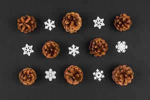 Top view of holiday composition made of pine cones and white snowflakes on colorful background. Winter time and Christmas concept with copy space photo