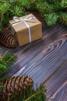 Gift box with fir branches on wooden background photo