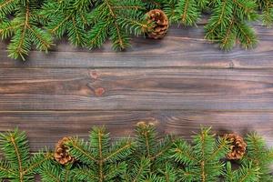 Christmas gray wooden background with fir tree frame and cones copy space. top view empty space for your design photo
