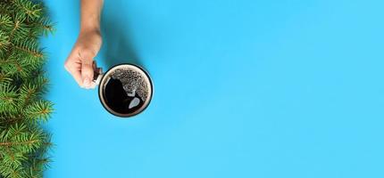 Minimalistic style woman hand holding a mug of coffee on purple background. Flat lay, banner top view photo