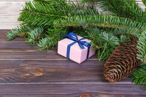 rama de árbol de navidad, decoraciones y caja de regalo en mesa de madera blanca foto