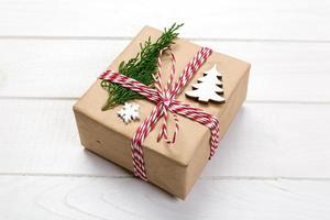 Christmas gift box wrapped in recycled paper, with ribbon top view with copy space on rustic background. Holiday concept photo