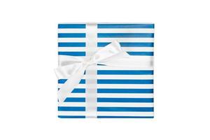 Christmas or other holiday handmade present in blue paper with white ribbon. Isolated on white background, top view. thanksgiving Gift box concept photo