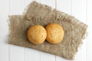 Freshly baked buns with seeds on wooden table photo