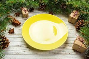 Perspective view. Empty plate round ceramic on wooden christmas background. holiday dinner dish concept with new year decor photo